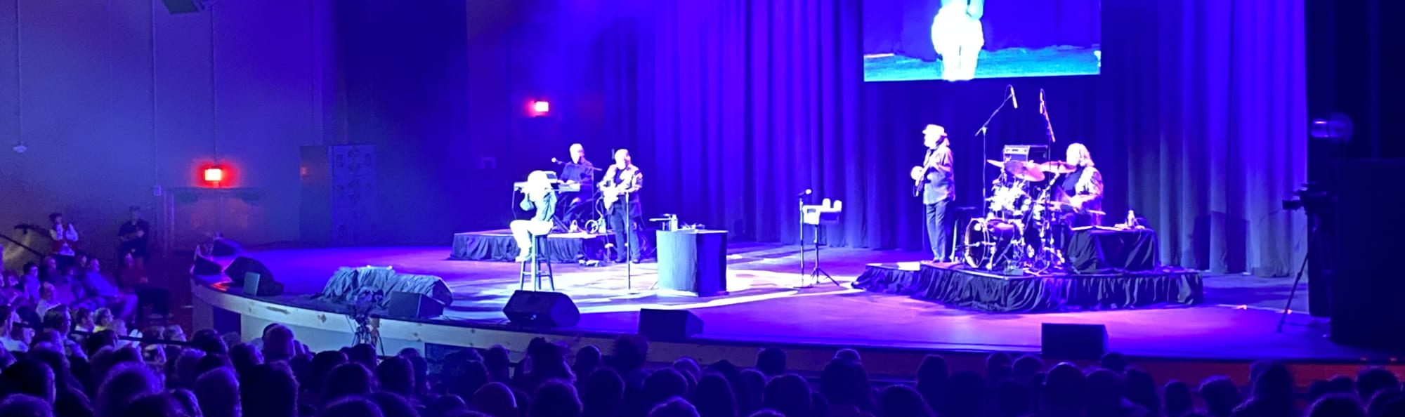 signer on stage in chair washed out by the lights College Station